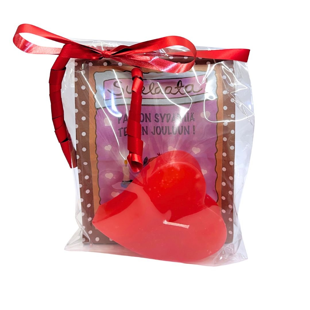 Sellofaanipussiin punaisella lahjanarulla paketoitu lahjasetti, jossa sydänkynttilä ja paperinen Vilippus-suklaapussi kissakuvituksella ja tekstillä "Paljon sydämiä teidän jouluun!"
