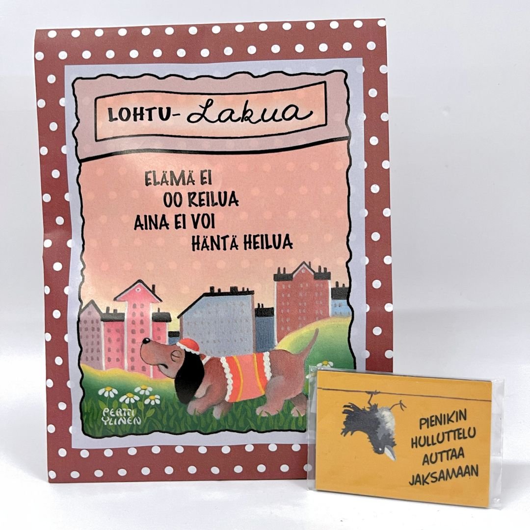 Lohtulahja: lakupussi, jonka etiketissä on kuvitus surullisesta koirasta, sekä tekstit "lohtu-lakua" ja "Elämä ei oo reilua, aina ei voi häntä heilua", sekä pieni magneetti oranssilla taustalla ja pää alaspäin roikkuvalla variksella, sekä teksti "Pienikin hulluttelu auttaa jaksamaan"